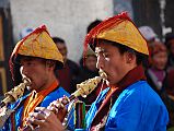 Mustang Lo Manthang Tiji Festival Day 2 13 Horn Players Two horn players dressed in yellow hats with red tassels and blue jackets played their horns at the Tiji Festival in Lo Manthang.
